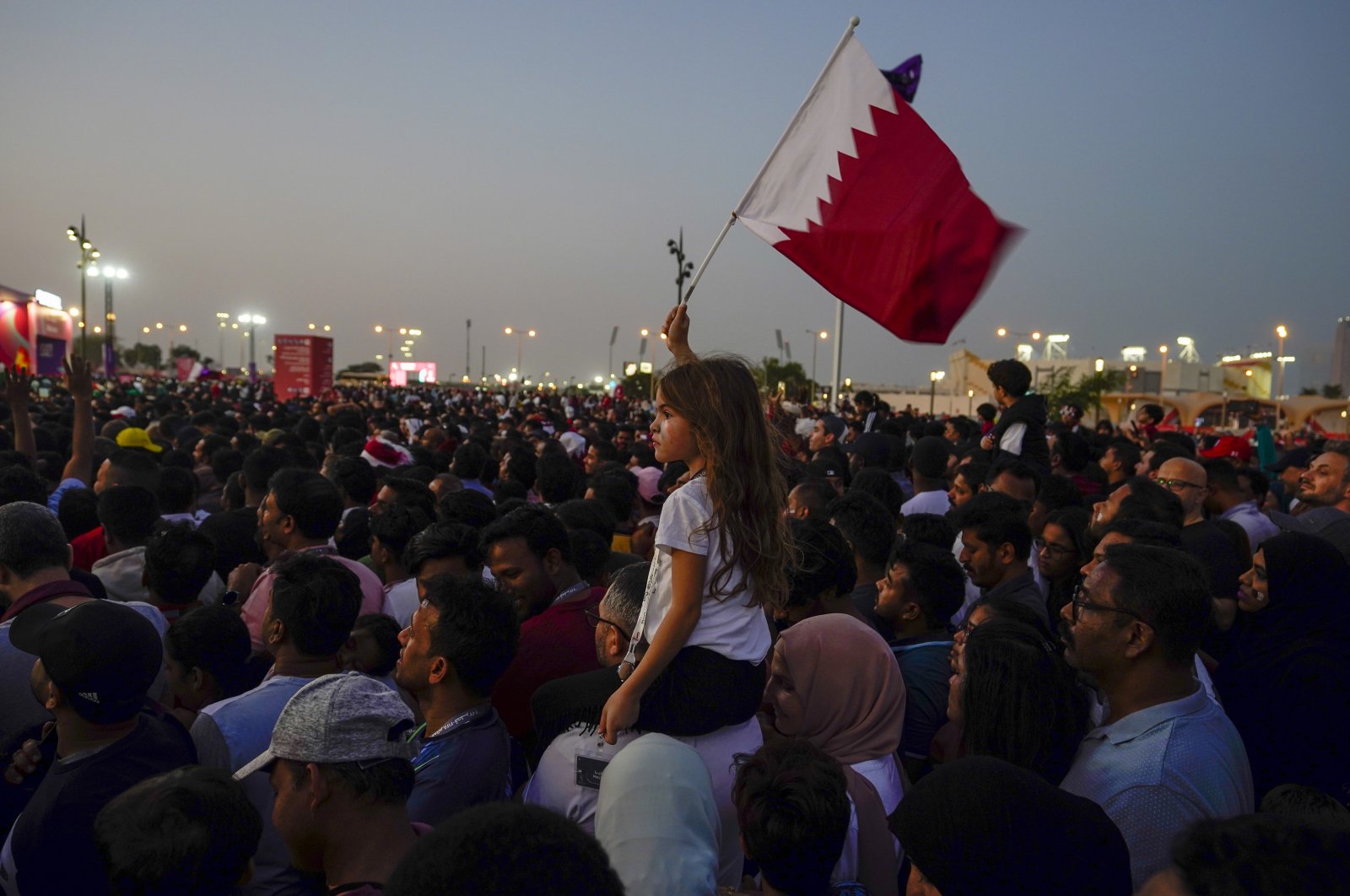 A girl waves a Qatari flag at a fan zone during the opening ceremony for the World Cup, prior to the group A soccer match between Qatar and Ecuador, in Doha, Qatar, Nov. 20, 2022. (AP Photo)