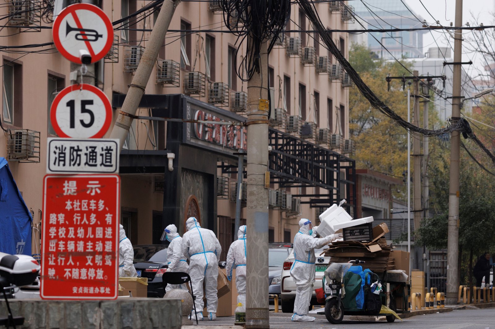 Pandemic prevention workers in protective suits collect trash in a locked-down residential compound as outbreaks of COVID-19 continue in Beijing, China, Nov. 18, 2022. (Reuters Photo)