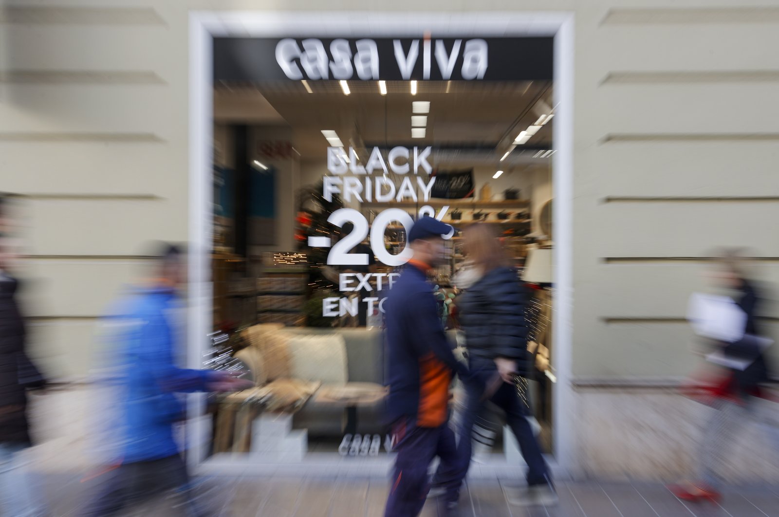 Some passers-by walk past a decor shop with a black friday sales banner in Valencia, eastern Spain, Nov.22, 2022. (EPA Photo)