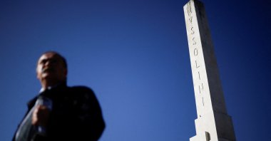 A man walks past an obelisk dedicated to fascist leader Benito Mussolini in Rome, Italy, Oct. 19, 2022. (Reuters Photo)
