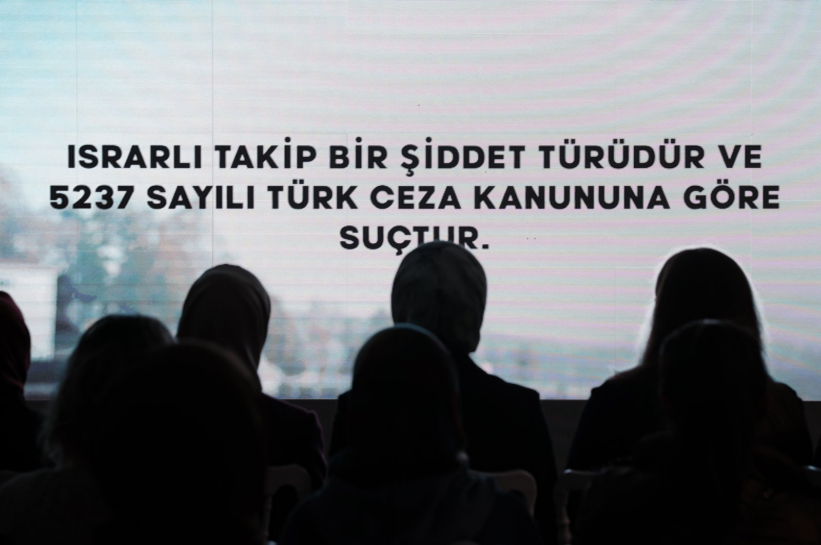 An audience watches a short video by the Women and Democracy Association (KADEM) as the point "Stalking is violence and a crime according to Turkish Penal Code No. 5237" is displayed on the screen, Istanbul, Türkiye, Nov. 24, 2022. (AA Photo)