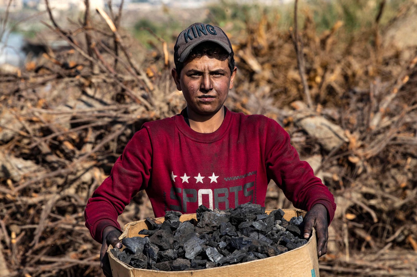 A worker carries a box of wood charcoal made for domestic use, in the countryside of Raqa in northern Syria, Nov. 23, 2022 (AFP Photo)