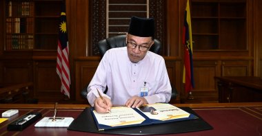 Malaysia&#039;s newly appointed Prime Minister Anwar Ibrahim signs a document as he clocks in to the prime minister&#039;s office on his first day holding the premier position at Putrajaya, Malaysia, Nov. 25, 2022. (Reuters Photo)