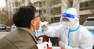 A health worker takes a swab sample from a resident to be tested for COVID-19 coronavirus, Jiayuguan, Gansu province, Nov. 24, 2022. (AFP Photo)