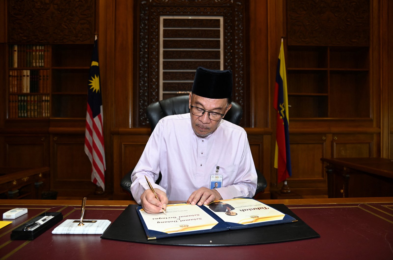 Malaysia&#039;s newly appointed Prime Minister Anwar Ibrahim signs a document as he clocks in to the prime minister&#039;s office on his first day holding the premier position at Putrajaya, Malaysia, Nov. 25, 2022. (Reuters Photo)