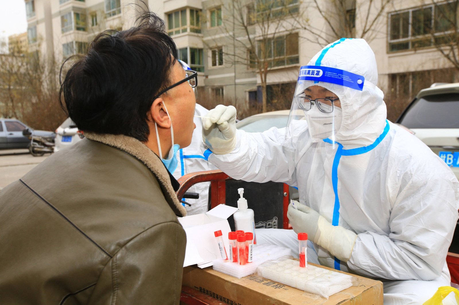 A health worker takes a swab sample from a resident to be tested for COVID-19 coronavirus, Jiayuguan, Gansu province, Nov. 24, 2022. (AFP Photo)