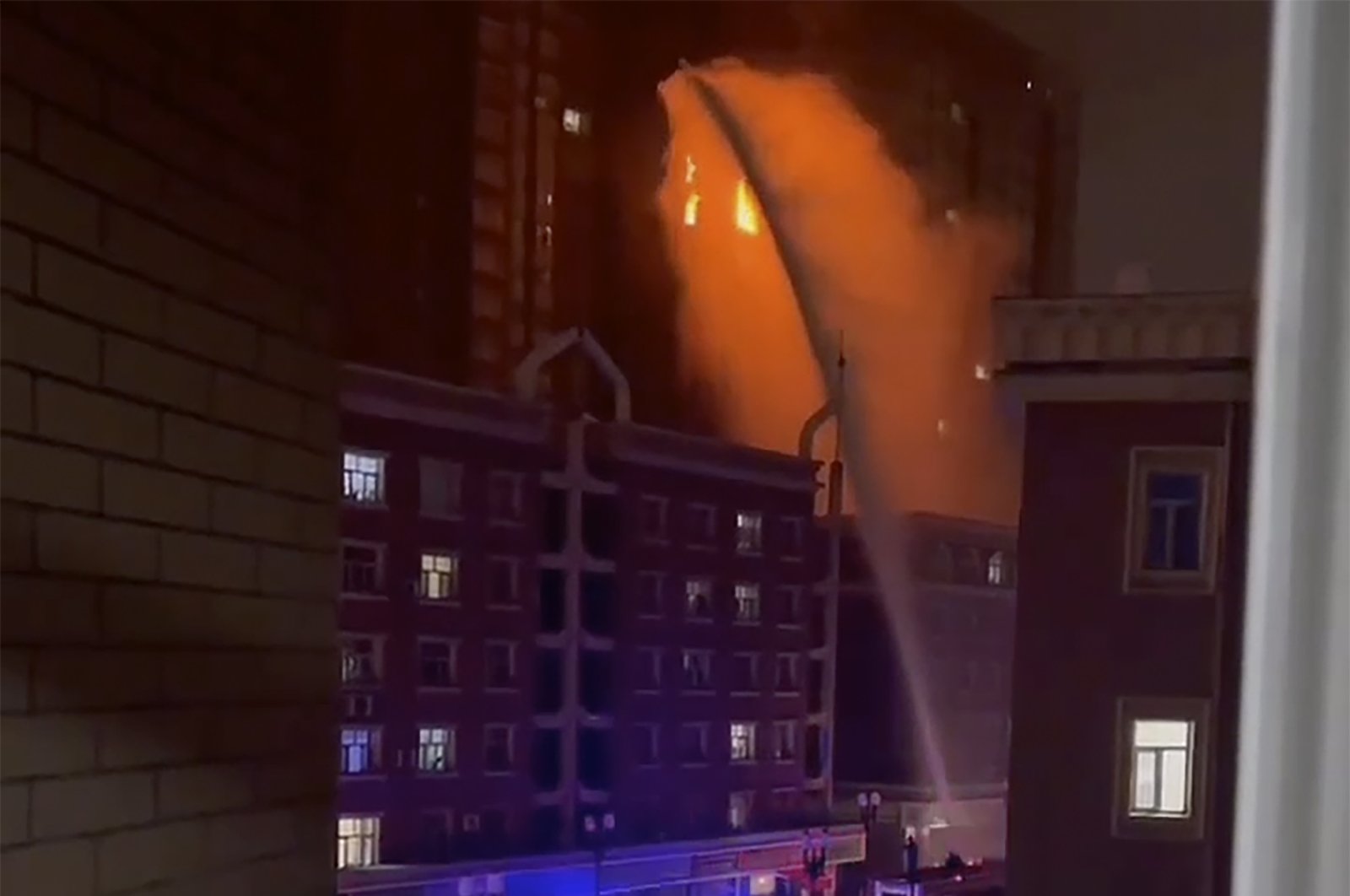 Firefighters spray water on a fire at a residential building in Urumqi, Xinjiang, China, Nov. 24, 2022. (AP Photo)