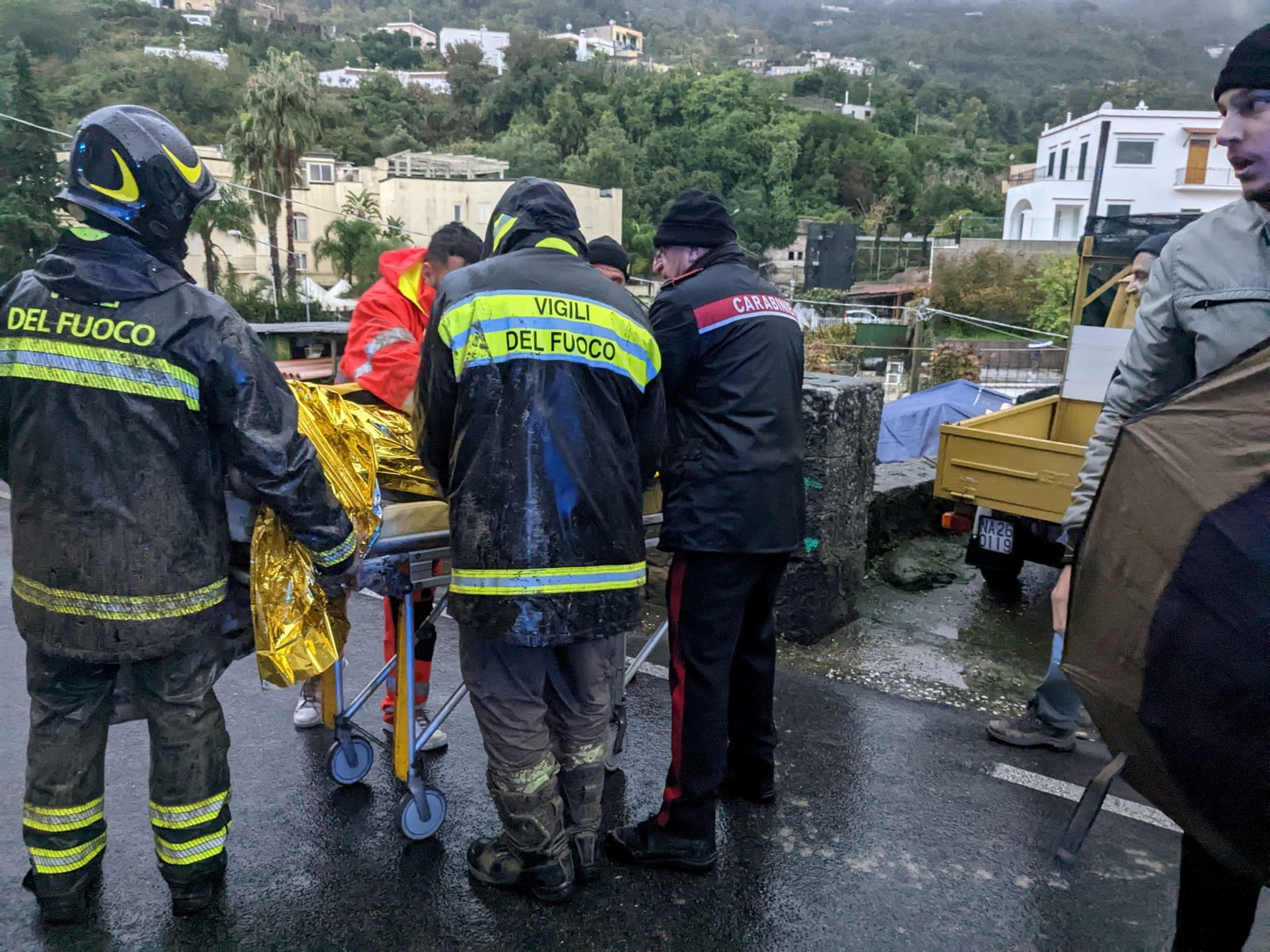 Kurtarma ekipleri, İtalya'nın tatil adası Ischia'da toprak kayması sonrasında yaralı bir kişiye yardım ediyor, 26 Kasım 2022. (Reuters Fotoğrafı)