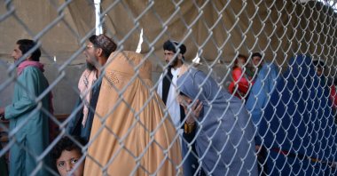 Afghans walk along a fenced corridor as they cross into Pakistan at the Afghanistan-Pakistan border in Spin Boldak, Nov. 21, 2022. (Photo by AFP)