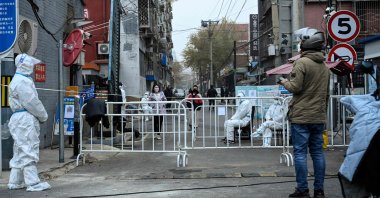 Security guards in personal protective equipment are seen at a residential compound under lockdown due to COVID-19 restrictions in Beijing, China, Nov. 24, 2022. (AFP Photo)
