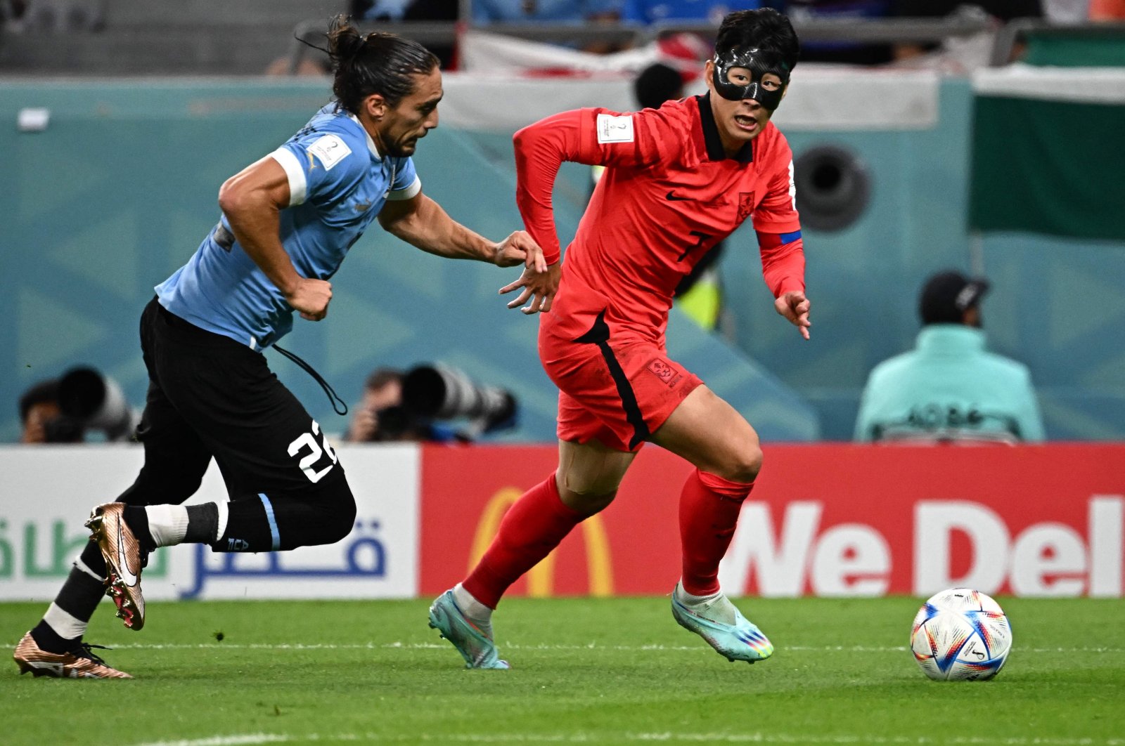 South Korea&#039;s midfielder Son Heung-min runs with the ball past Uruguay&#039;s defender Martin Caceres during the Qatar 2022 World Cup Group H football match between Uruguay and South Korea at the Education City Stadium, Al Rayyan, Doha, Nov. 24, 2022. (AFP Photo)