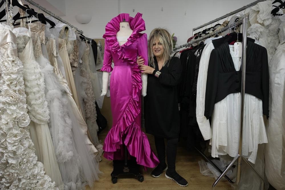 Desainer Inggris Elizabeth Emanuel berdiri di samping replika gaun malam yang dirancangnya untuk dikenakan Lady Diana Spencer saat itu di pesta Istana Buckingham beberapa hari sebelum pernikahannya dengan Pangeran Charles pada 1981, London, Inggris, 18 November 2022. ( Foto AP)