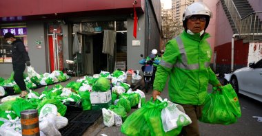 A delivery worker picks up goods at a logistics station of the online grocery platform Meituan, following the COVID-19 outbreak in Beijing, China, Nov. 23, 2022. (Reuters Photo)