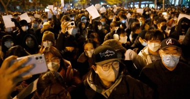 Protesters march along a street during a rally for the victims of a deadly fire as well as a protest against China's harsh COVID-19 restrictions, Beijing, China, Nov. 28, 2022.