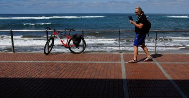 50-year-old Russian Victor Varlamov talks on his phone from Las Canteras Beach Avenue in Las Palmas de Gran Canaria, on the island of Gran Canaria, Spain, Nov., 9, 2022. (Reuters Photo) 
