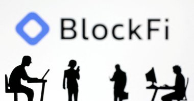 Figurines with smartphones and computers are seen in front of the BlockFi logo in this illustration, Nov. 28, 2022. (Reuters Photo)