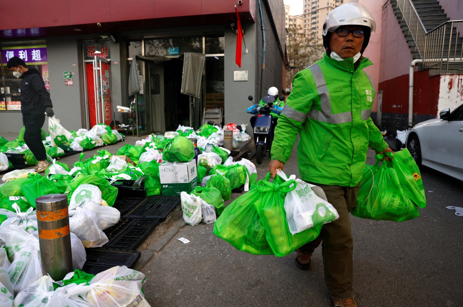 A delivery worker picks up goods at a logistics station of the online grocery platform Meituan, following the COVID-19 outbreak in Beijing, China, Nov. 23, 2022. (Reuters Photo)