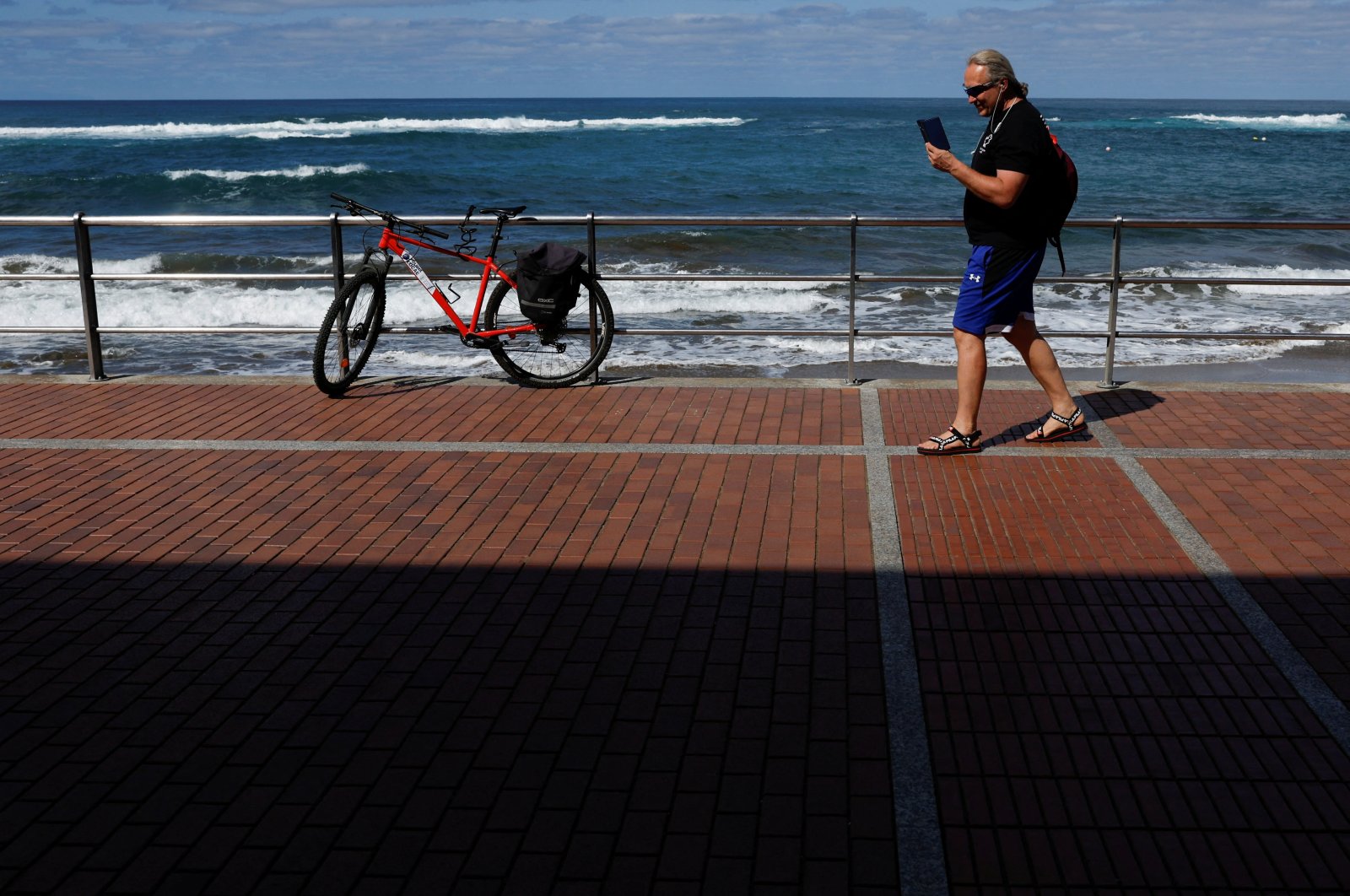 50-year-old Russian Victor Varlamov talks on his phone from Las Canteras Beach Avenue in Las Palmas de Gran Canaria, on the island of Gran Canaria, Spain, Nov., 9, 2022. (Reuters Photo) 