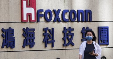 A woman walks past the logo of Foxconn outside the company&#039;s building in Taipei, Taiwan, Nov., 9, 2022. (Reuters Photo)