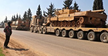 A boy looks at a convoy of Turkish military vehicles near the town of Hazano in the opposition-held northern countryside of Syria's Idlib province, March 3, 2020. (AFP Photo)