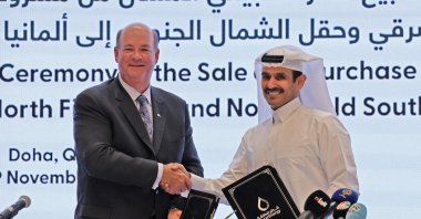Saad Sherida Al Kaabi (R), CEO of QatarEnergy, and Ryan Lance (L), CEO of multinational corporation ConocoPhillips, exchange documents during a press conference announcing a new deal to send Qatari LNG to Germany, Doha, Qatar, Nov. 29, 2022. (AFP Photo)