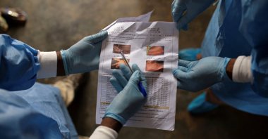 A local health official and a nurse consult documents containing information about monkeypox at the Yalolia health center, in Yakusu, Tshopo, Democratic Republic of Congo, Oct. 3, 2022. (Reuters Photo)