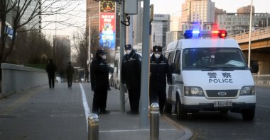 Police keep watch on a road by the Liangma River, where recent protests took place against China's harsh COVID-19 restrictions, Beijing, China, Nov. 29, 2022. (AFP Photo)
