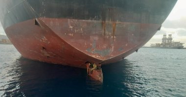 Three stowaway migrants are seen on the rudder blade of petrol vessel Althini II after traveling from Nigeria and before being rescued by Spanish coast guard, in this picture released on the Salvamento Maritimo official Twitter account, at sea near Las Palmas de Gran Canaria port, in the Canary Islands, Spain Nov. 28, 2022. (Salvamento Maritimo/Handout via Reuters)