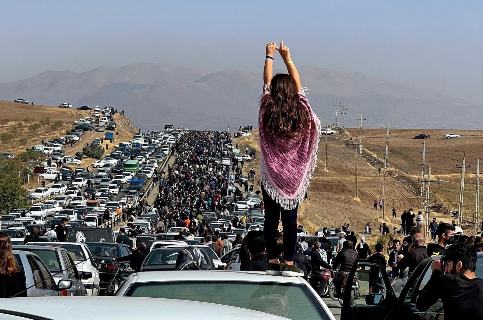 A woman stands on top of a vehicle as thousands make their way toward the grave of Mahsa Amini, Saqez, Iran, Oct. 26, 2022. (AFP Photo)