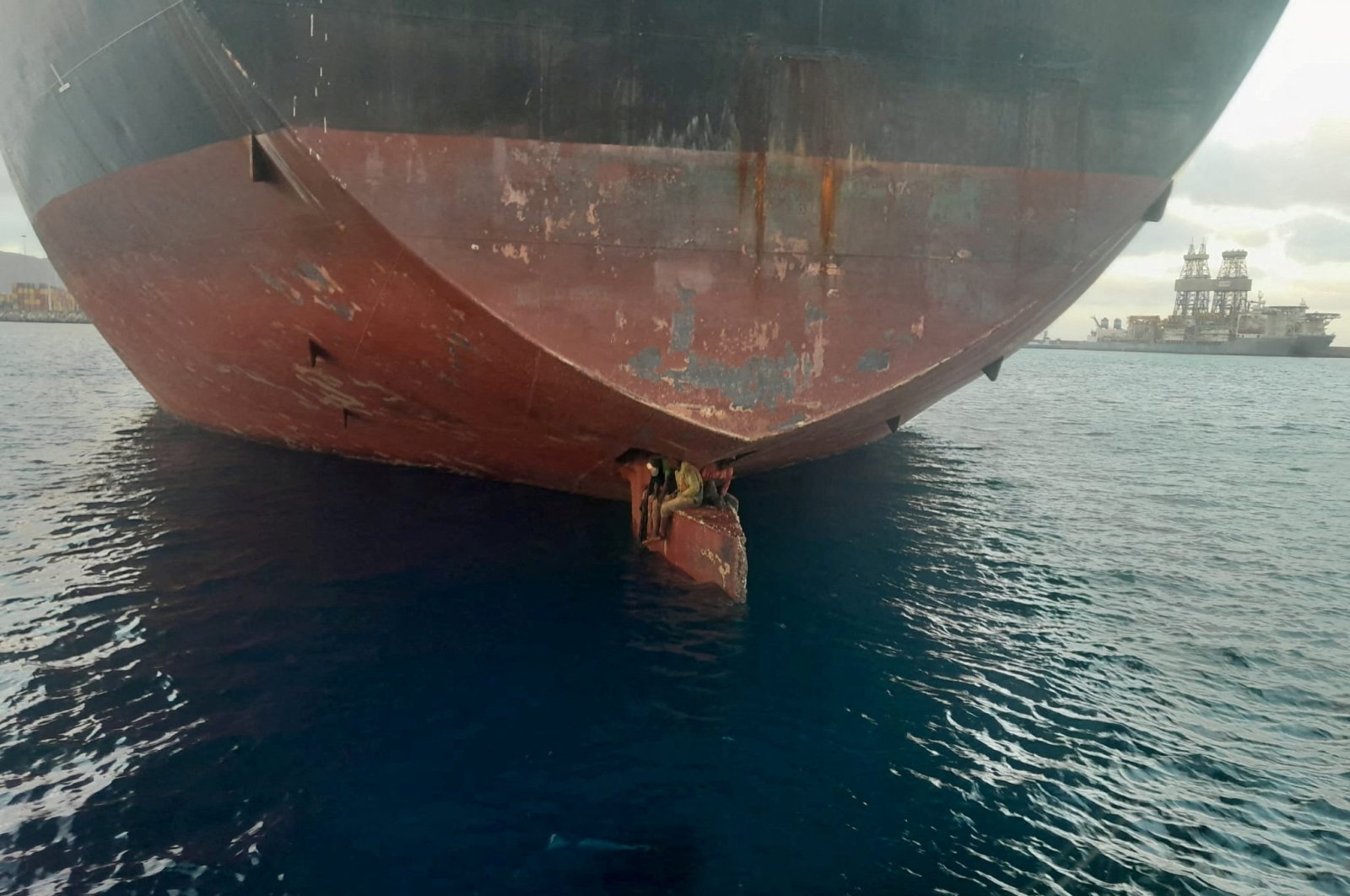 Three stowaway migrants are seen on the rudder blade of petrol vessel Althini II after traveling from Nigeria and before being rescued by Spanish coast guard, in this picture released on the Salvamento Maritimo official Twitter account, at sea near Las Palmas de Gran Canaria port, in the Canary Islands, Spain Nov. 28, 2022. (Salvamento Maritimo/Handout via Reuters)