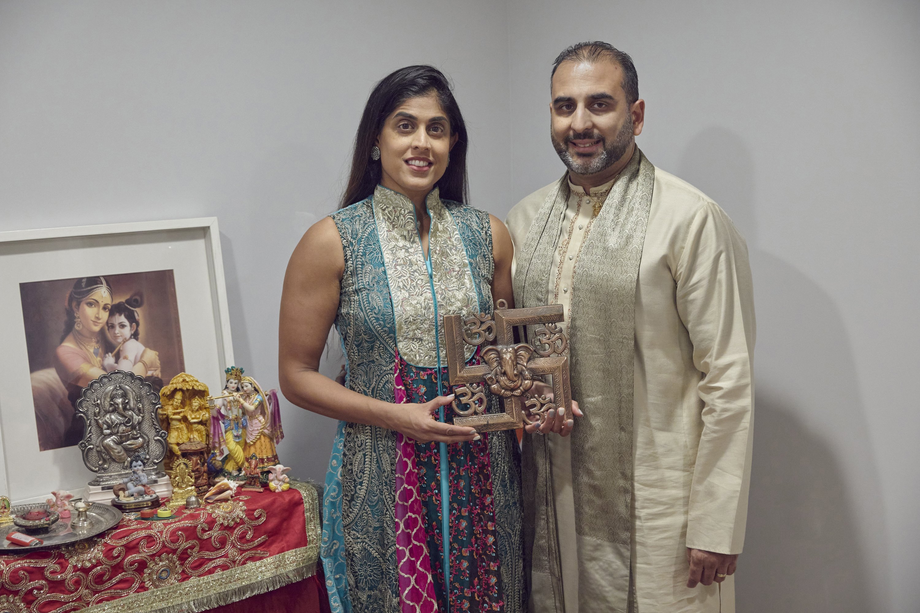 Sheetal Deo dan suaminya, Sanmeet Deo, memegang simbol swastika Hindu di rumahnya di Syosset, New York, 13 November 2022. (Foto AP)
