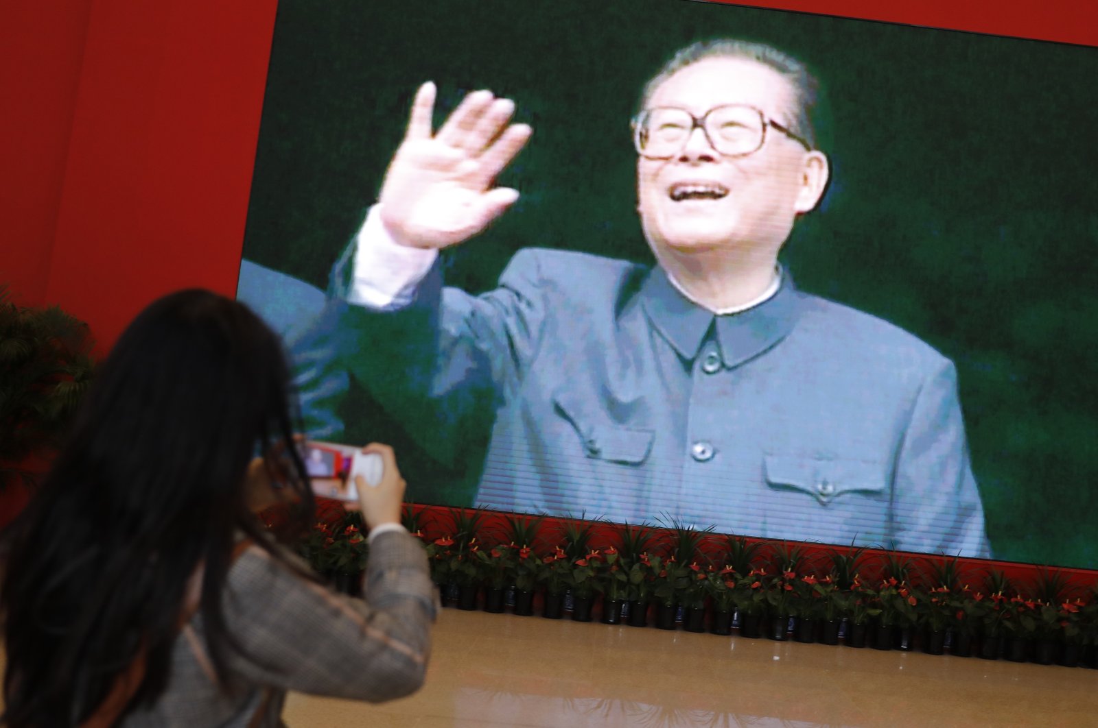 People take photos of a poster showing former Chinese President Jiang Zemin, Beijing, China, Nov. 30, 2022. (IHA Photo)