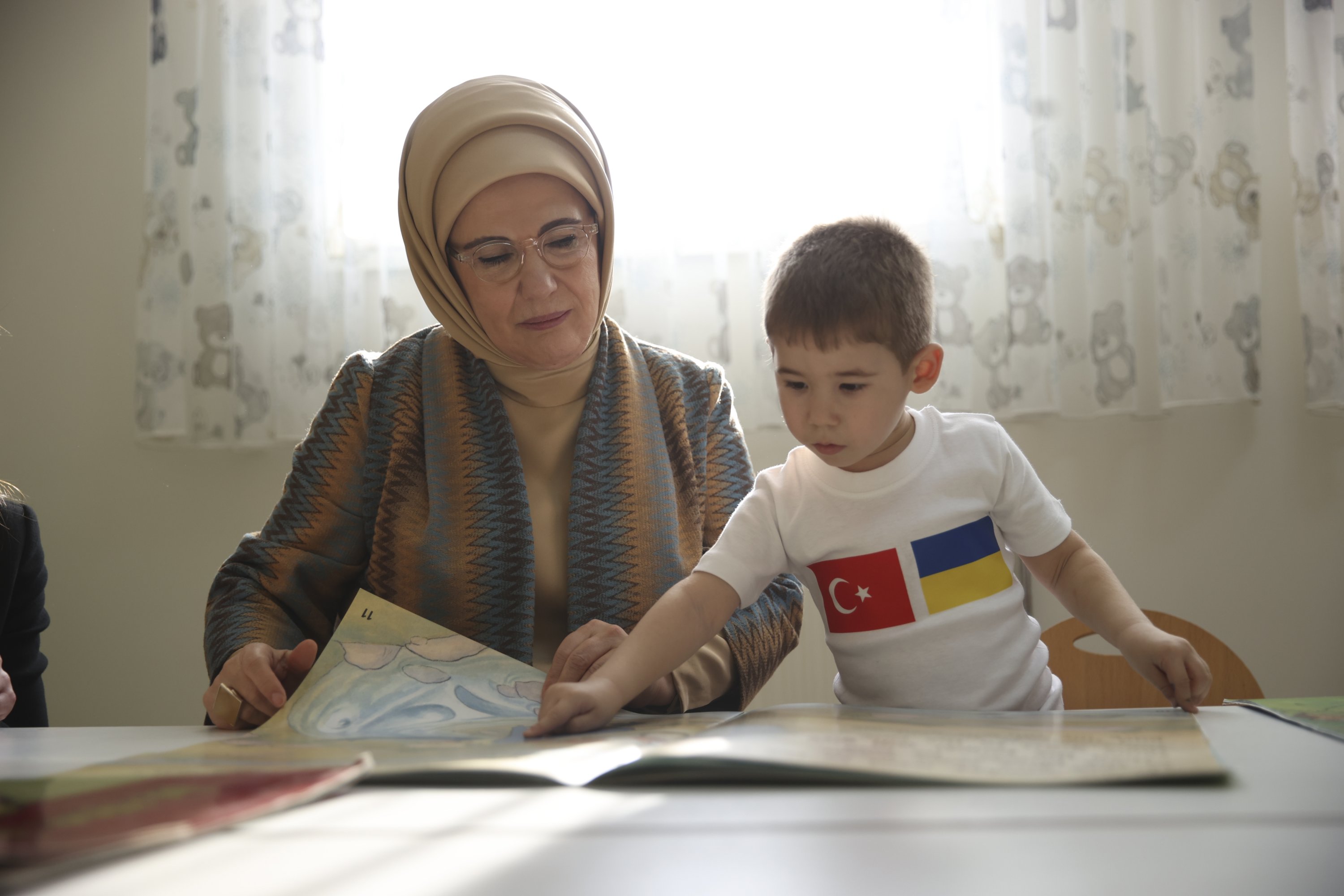 Seorang anak laki-laki Ukraina menunjukkan bukunya kepada ibu negara Emine Erdoğan, di ibu kota Ankara, Türkiye, 1 Desember 2022. (Foto AA)