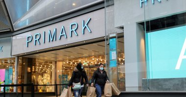 Customers walk with shopping bags, close to retail store Primark in Birmingham, U.K., April 12, 2021. (Reuters Photo)