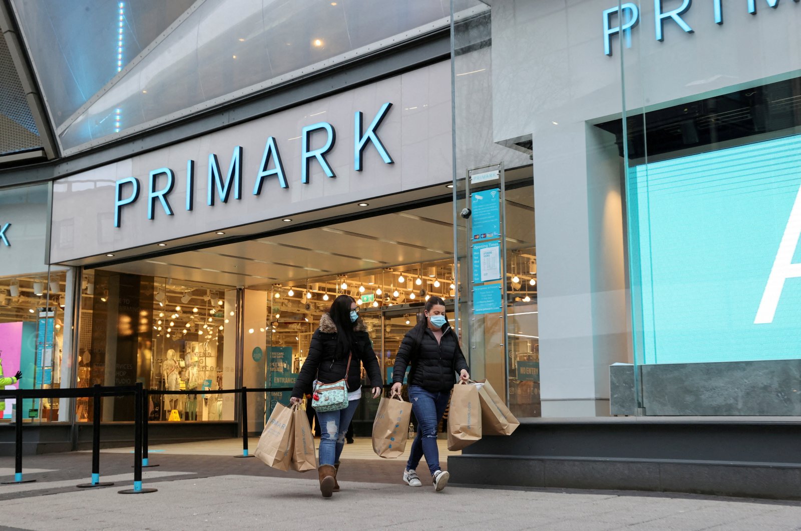 Customers walk with shopping bags, close to retail store Primark in Birmingham, U.K., April 12, 2021. (Reuters Photo)