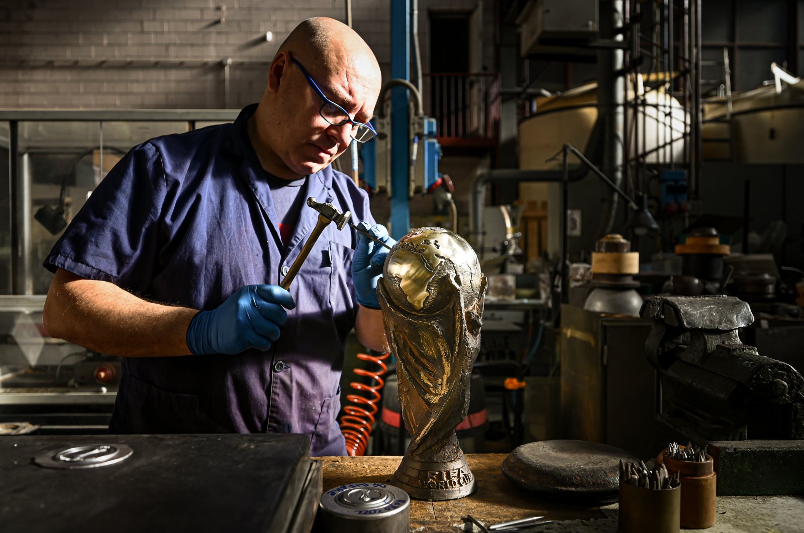 A craftsman works on the FIFA World Cup trophy replica at GDE Bertoni firm, Paderno Dugnano, Italy, Nov. 30, 2022. (AA Photo)