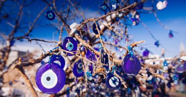 Evil eyes hang on the branches of a tree to ward off the bad spirits, Cappadocia region, Nevşehir, central Türkiye. (Shutterstock Photo)