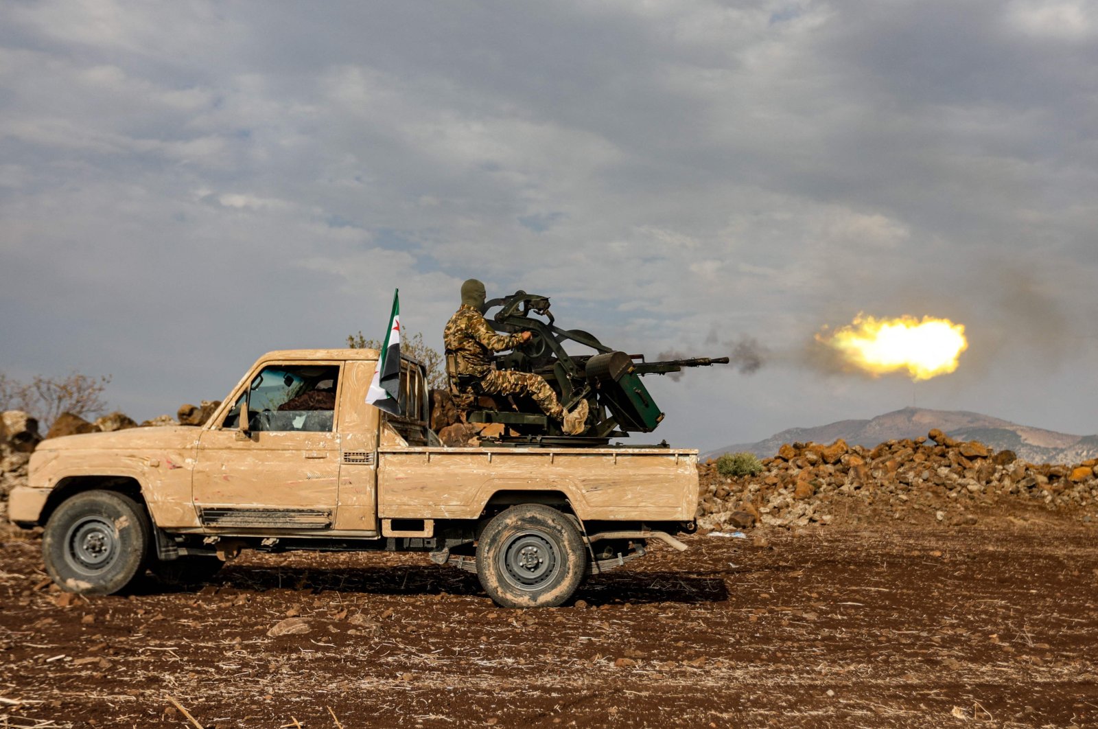 An opposition fighter fires a turret in the back of a &quot;technical&quot; vehicle during military drills by the &quot;Suleiman Shah Division&quot; in the opposition-held Afrin region of northern Syria, Nov. 22, 2022. (AFP Photo)