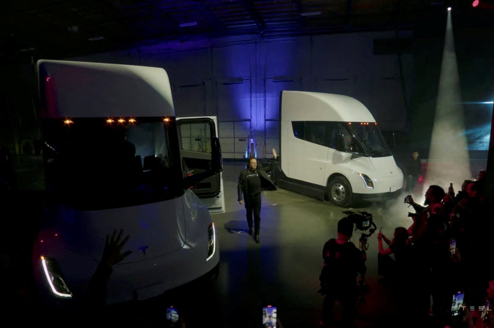 Tesla Chief Executive Elon Musk waves near Tesla Semi electric trucks during a live-streamed unveiling in Nevada, U.S. Dec. 1, 2022, in this still image taken from video. (Tesla Handout via REUTERS)