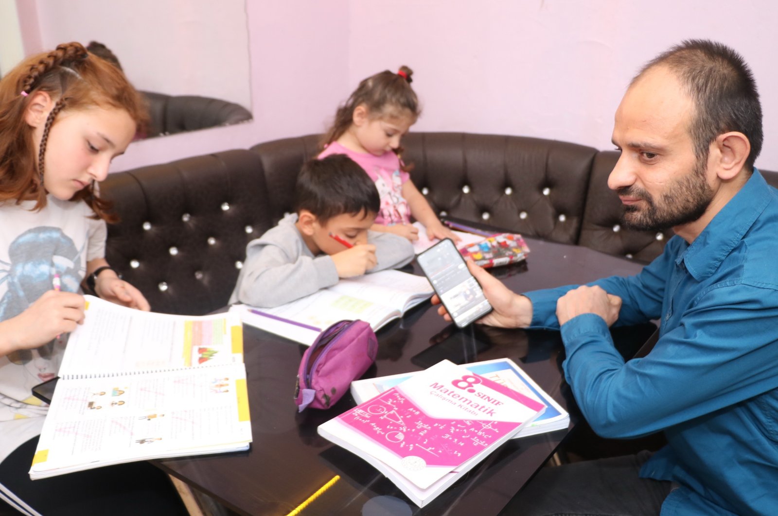 Cihan Dinçer, a visually impaired father, helps his kids with their homework in Zonguldak, Türkiye, Dec. 2, 2022. (IHA Photo)