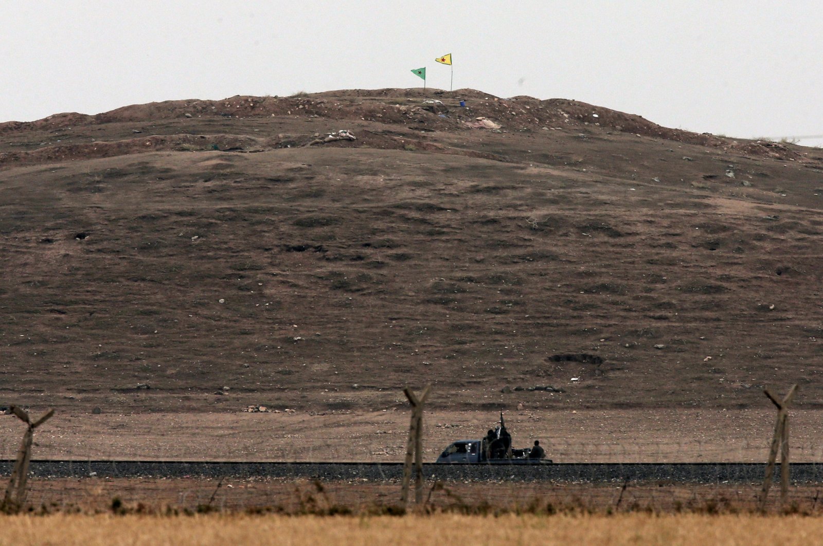 In this image shot with an extreme telephoto lens from the outskirts of Suruç on the Türkiye-Syria border, YPG/PKK terrorists are seen in a truck along the border road in Ain al-Arab, Syria, Oct. 17, 2014. (AP File Photo)
