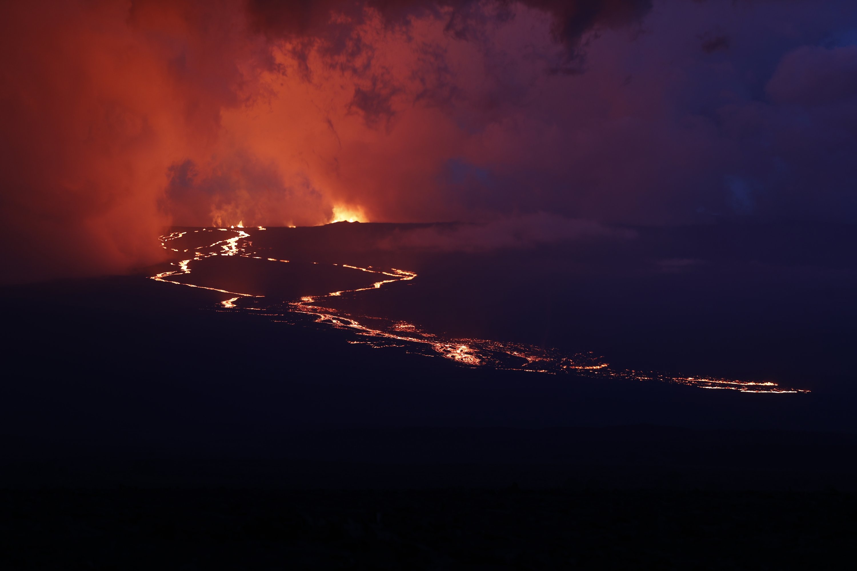 Lava mengalir menuruni gunung dari letusan Mauna Loa, dekat Hilo, Hawaii, AS, 29 November 2022. (Foto AP)