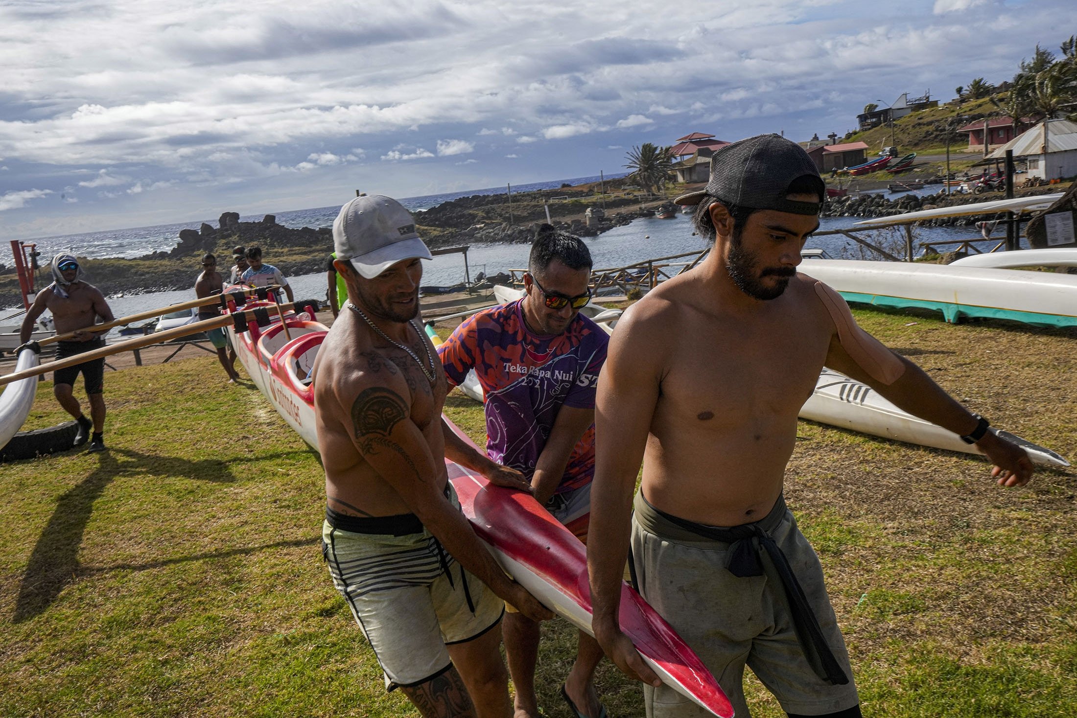 Anggota kru Rapanuis membawa kano mereka selama sesi pelatihan untuk tantangan Hoki Mai, di Rapa Nui, wilayah yang merupakan bagian dari Chili dan lebih dikenal sebagai Pulau Paskah, 24 November 2022. (Foto AP)