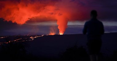 A man looks on as lava erupts from Hawaii&#039;s Mauna Loa volcano, near Hilo, Hawaii, U.S., Nov. 30, 2022. (AP Photo)