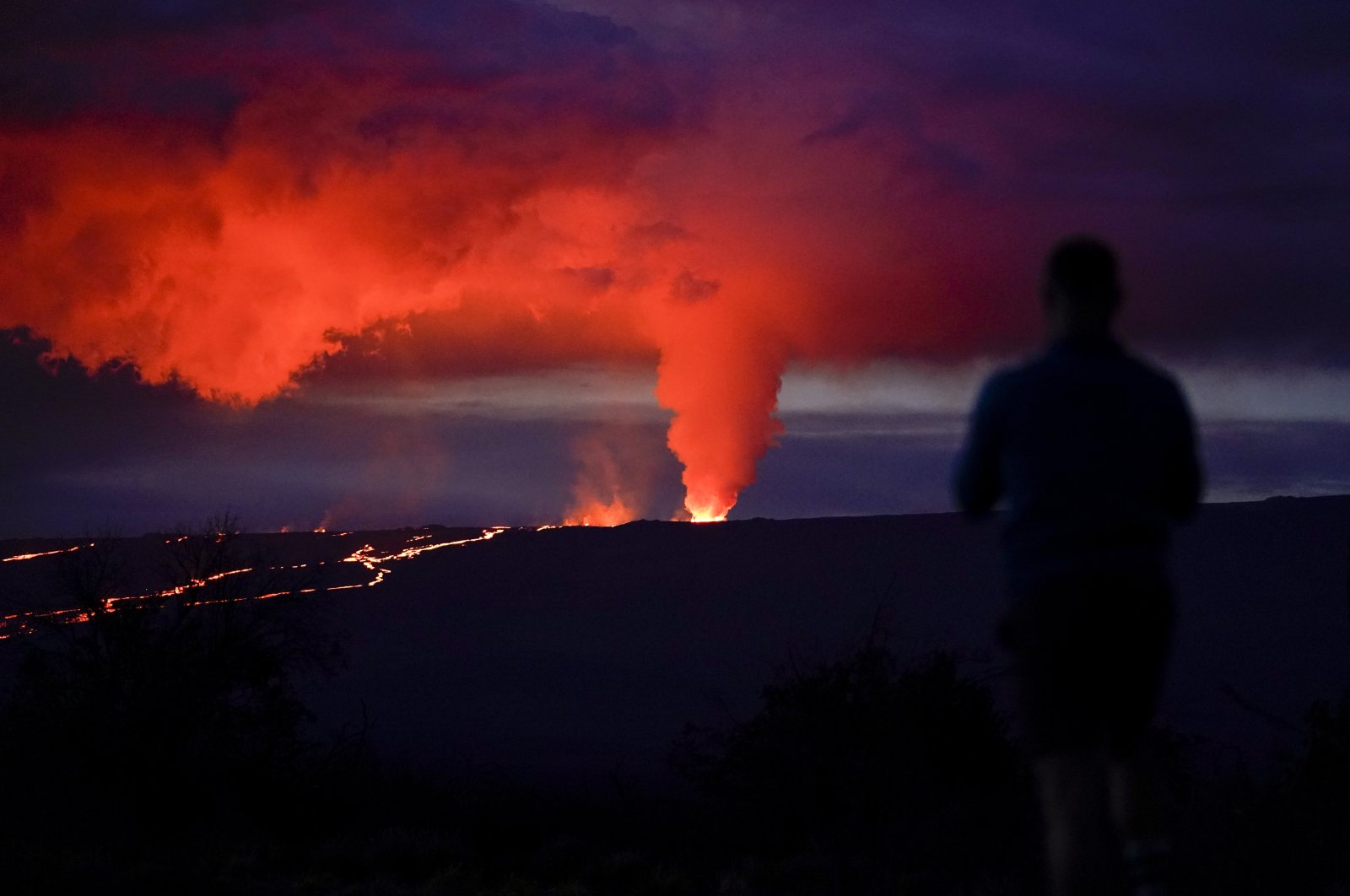 A man looks on as lava erupts from Hawaii&#039;s Mauna Loa volcano, near Hilo, Hawaii, U.S., Nov. 30, 2022. (AP Photo)