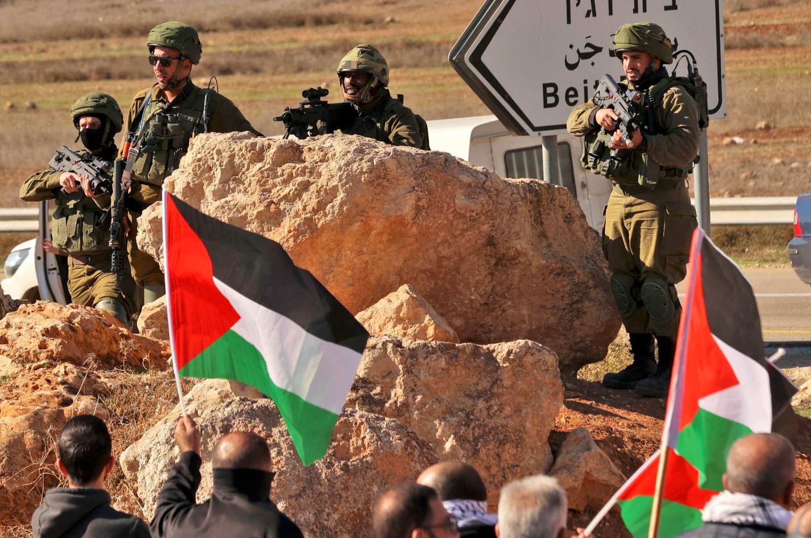 Israeli security forces take position as Palestinians wave national flags during a protest in Beit Dajan, east of the occupied West Bank city of Nablus, against the establishment of Israeli outposts, on Dec. 2, 2022. (AFP Photo)