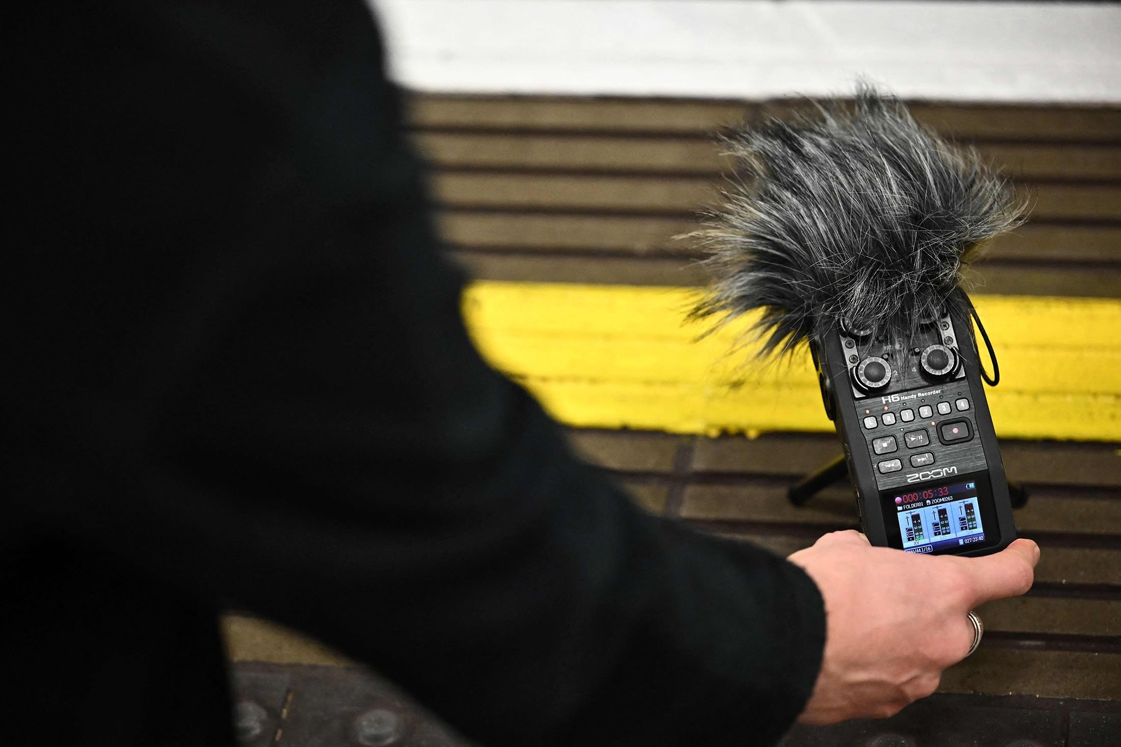 Müzisyen ve ses sanatçısı Stuart Fowkes, 28 Kasım 2022, Londra, Birleşik Krallık'taki Blackfriars metro istasyonunda Londra Metrosu'ndan geçen bir trenin sesini kaydediyor. (AFP Fotoğrafı)