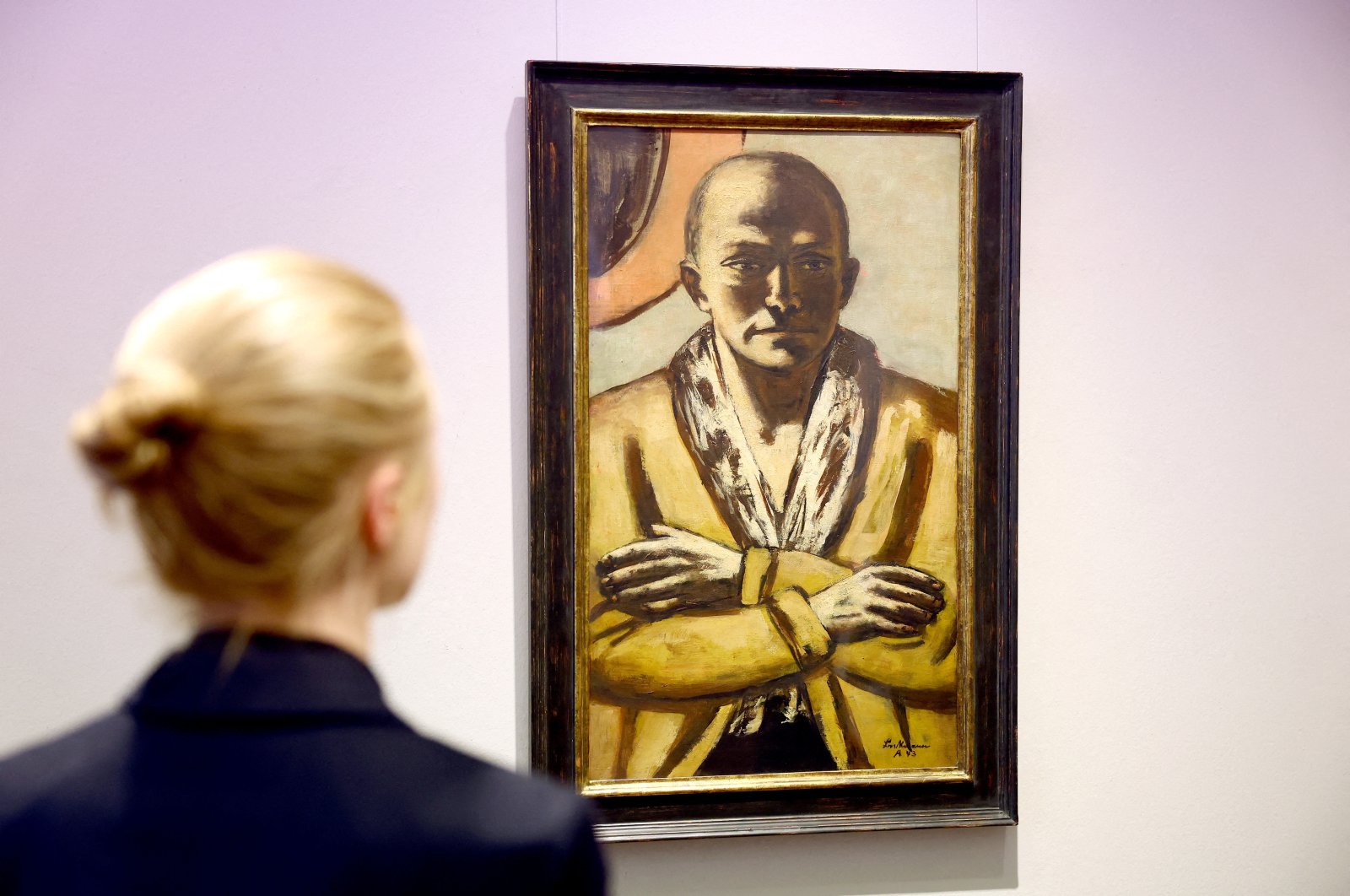 A woman looks at a self-portrait of German artist Max Beckmann &quot;Selbstbildnis gelb-rosa 1943 Amsterdam,&quot; Berlin, Germany, Nov. 25, 2022. (Reuters Photo)