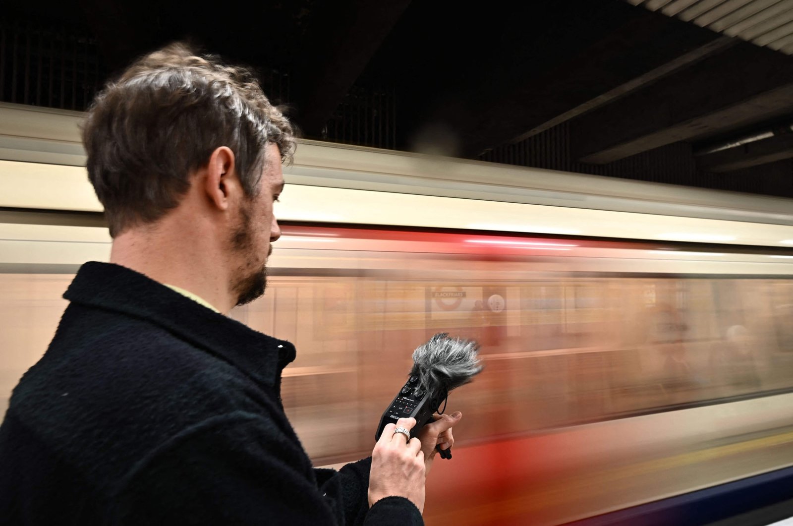 Musician and sound artist Stuart Fowkes records the sound of a passing London Underground train at Blackfriars tube station in London, U.K., Nov 28, 2022. (AFP Photo)