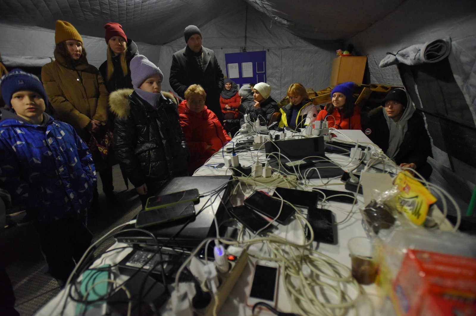 People charge their devices from a power generator at a heating point, Kyiv, Ukraine, Nov. 24, 2022. (EPA Photos)